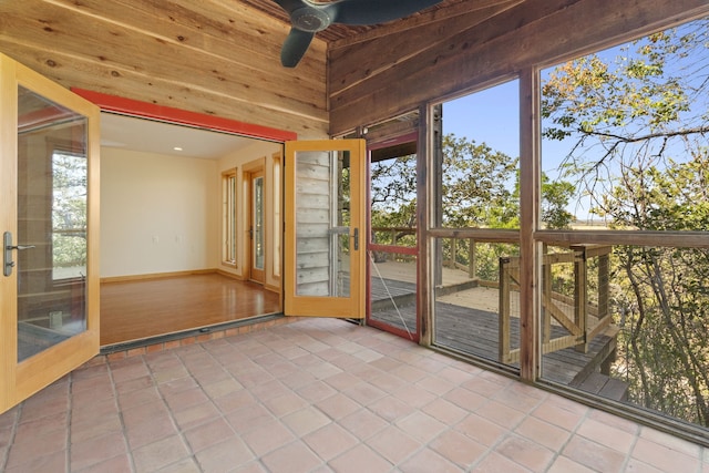 unfurnished sunroom with ceiling fan