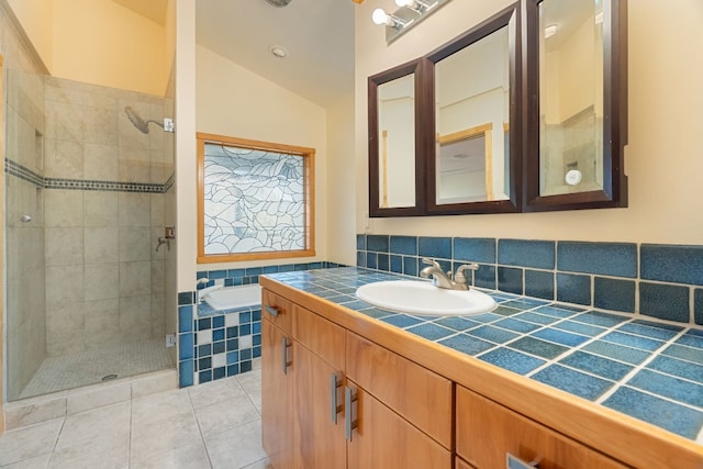 212 Comanche Cp, Kyle, TX 78640 - full bathroom with a stall shower, vaulted ceiling, tile patterned flooring, vanity, and a garden tub