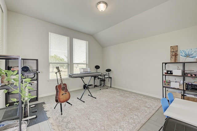 office area with a healthy amount of sunlight, lofted ceiling, and light hardwood / wood-style flooring