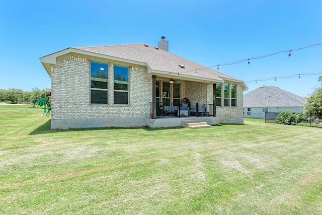 back of house with ceiling fan, a porch, and a lawn