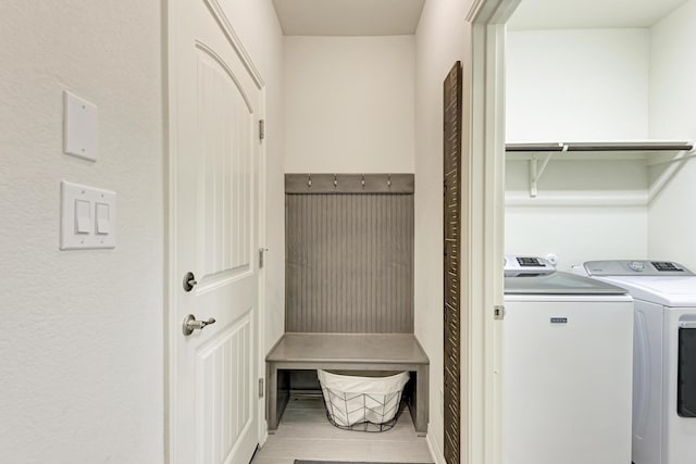 laundry area with washer and dryer and light tile patterned floors