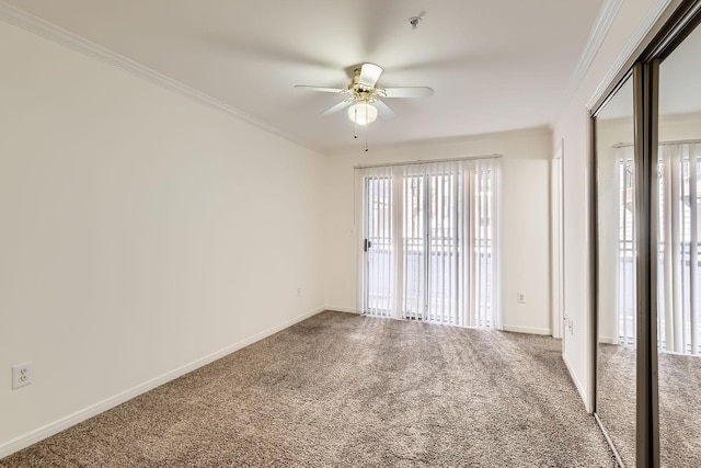 spare room with carpet floors, ornamental molding, and ceiling fan