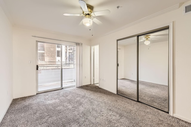 unfurnished bedroom with crown molding, ceiling fan, carpet flooring, and a closet