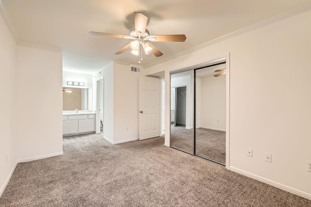 unfurnished bedroom featuring carpet floors, ornamental molding, a closet, and ceiling fan