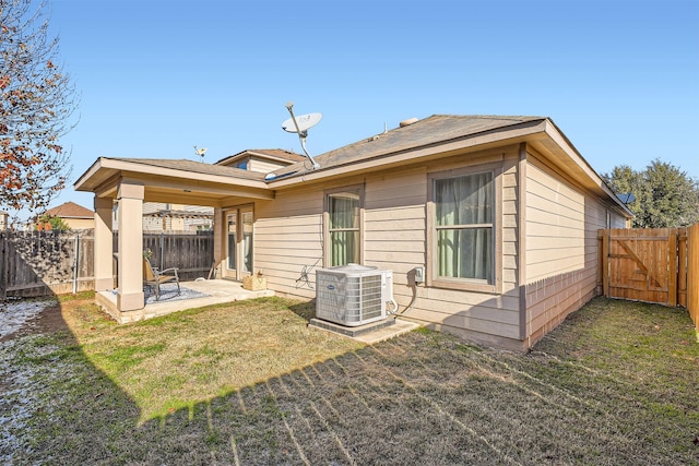 rear view of house with a patio, central AC unit, and a lawn