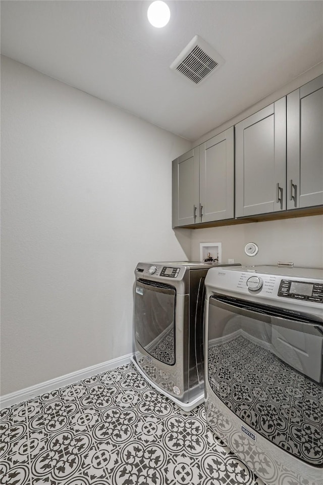 washroom featuring cabinets and washer and dryer