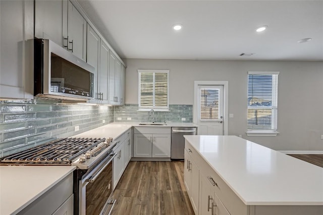 7001 Lewiston Way, Austin, TX 78724 - kitchen with stainless steel appliances, dark wood-style floors, light countertops, decorative backsplash, and recessed lighting