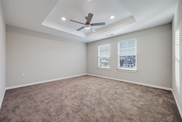 unfurnished room with ceiling fan, a tray ceiling, and carpet