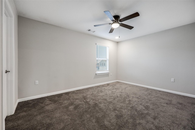 spare room with dark carpet and ceiling fan