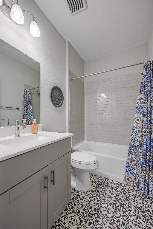 7001 Lewiston Way, Austin, TX 78724 - full bathroom featuring vanity, shower / bath combo with shower curtain, and tile patterned floors