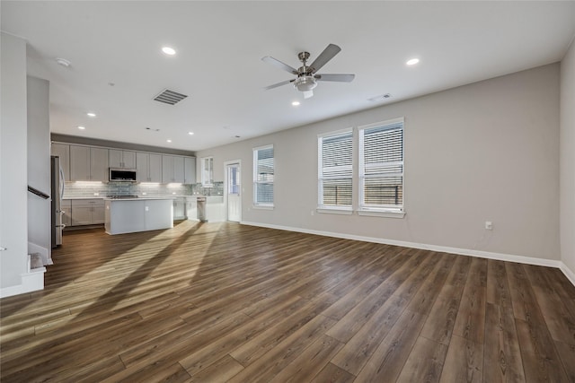 unfurnished living room with dark wood-type flooring and ceiling fan