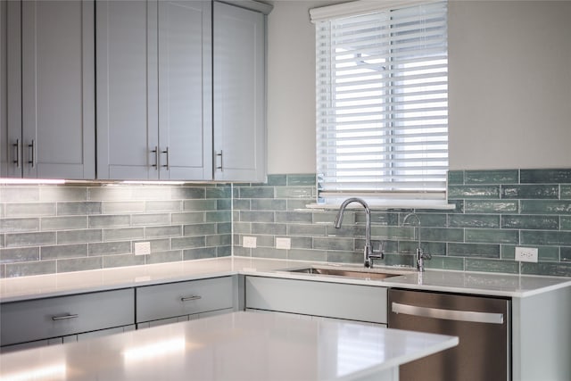 kitchen featuring gray cabinets, dishwasher, and sink