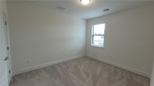 spare room featuring light colored carpet