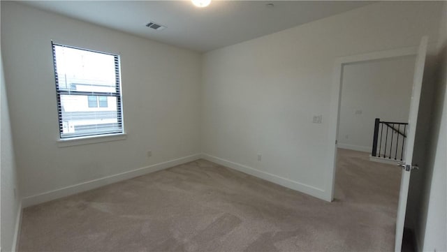 unfurnished room featuring light carpet