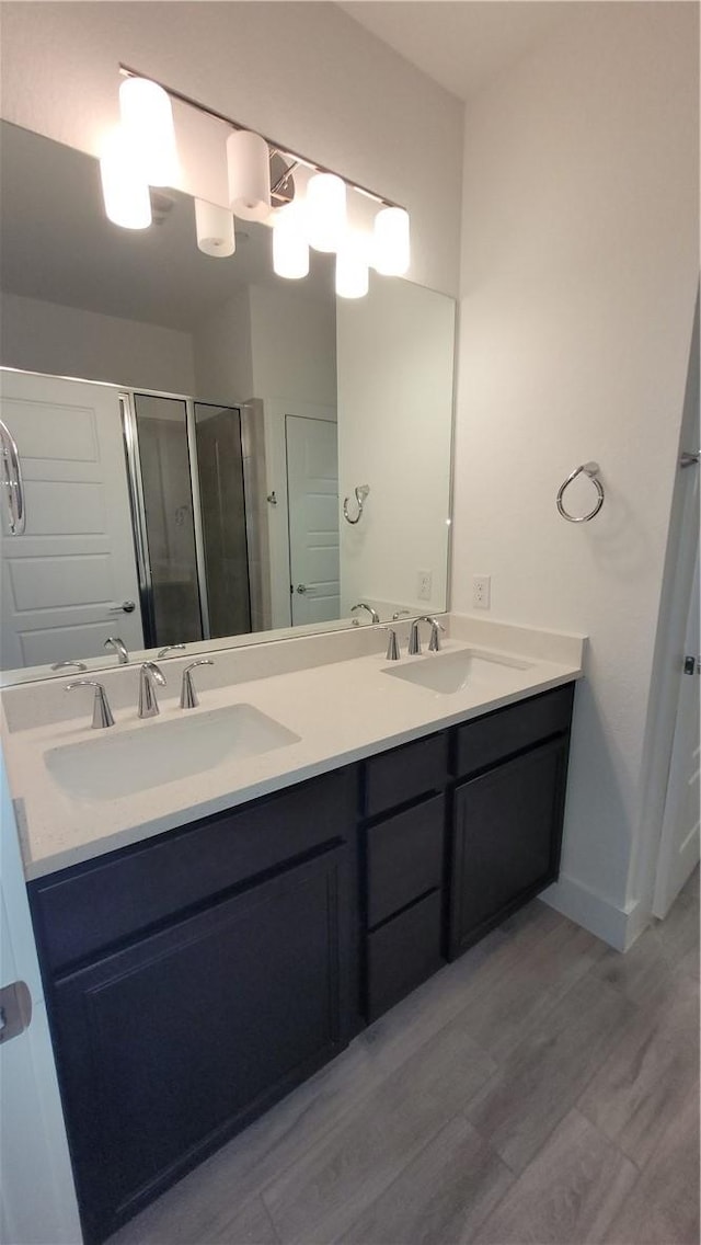 bathroom with vanity, hardwood / wood-style floors, and a shower with shower door