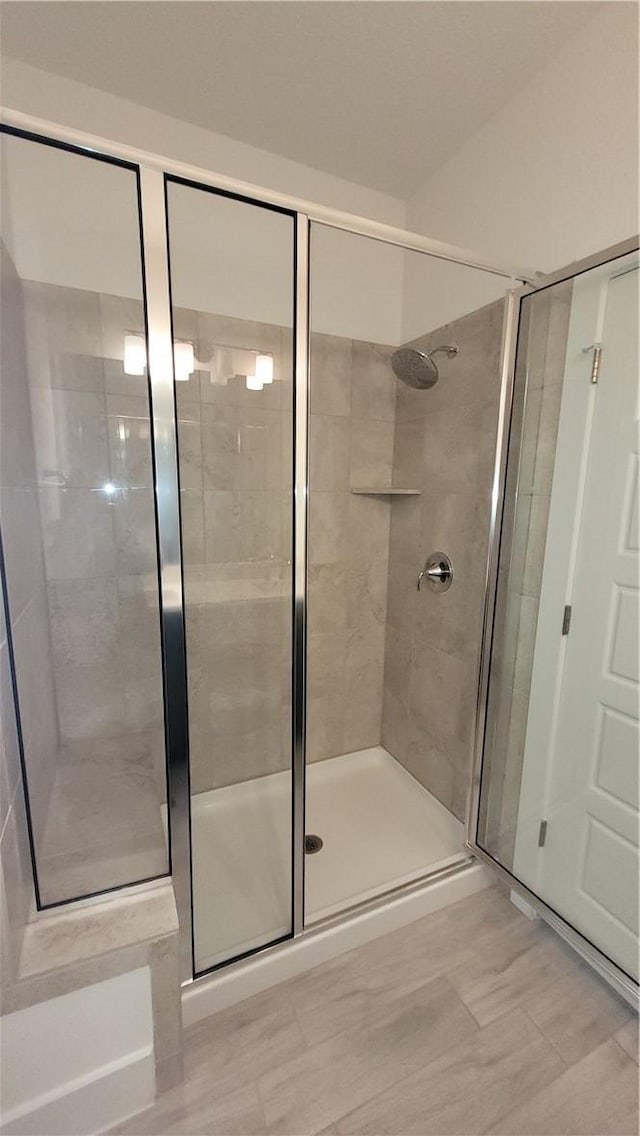 bathroom with an enclosed shower and tile patterned floors