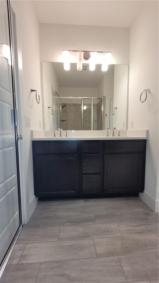 bathroom featuring vanity and a shower with shower door