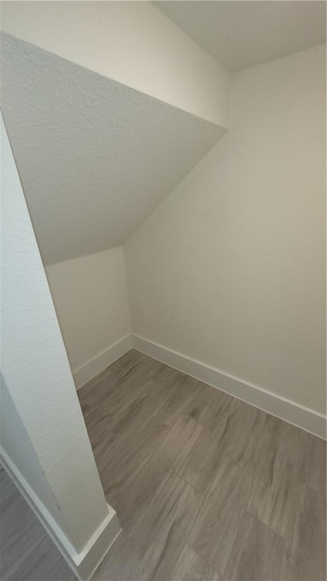 bonus room with vaulted ceiling and hardwood / wood-style floors