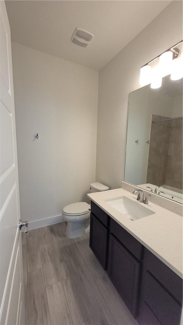 bathroom featuring wood-type flooring, vanity, and toilet