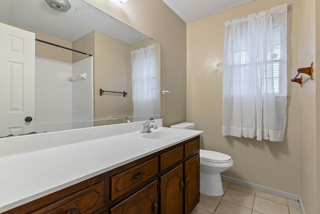 bathroom featuring tile patterned flooring, vanity, a textured ceiling, toilet, and walk in shower