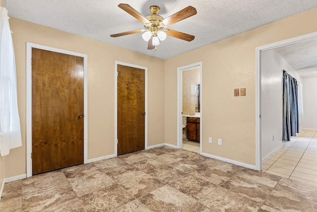 unfurnished bedroom featuring connected bathroom, a textured ceiling, and ceiling fan