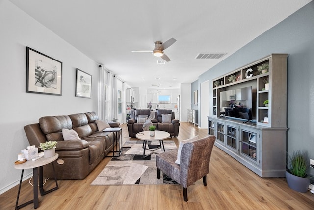 living room with ceiling fan and light hardwood / wood-style flooring