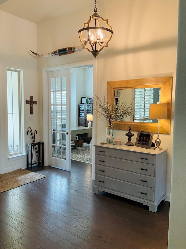 entryway with dark wood-type flooring, french doors, and a notable chandelier