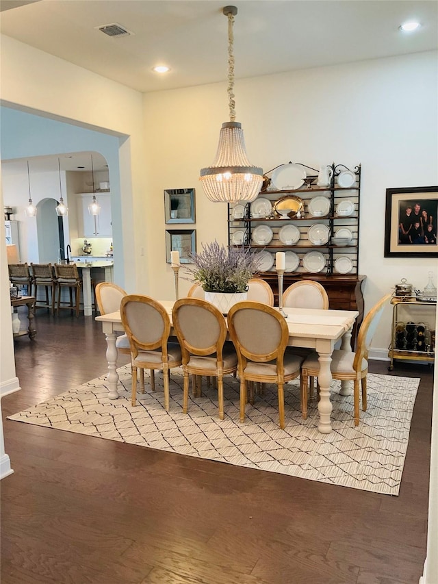 dining space with hardwood / wood-style flooring and an inviting chandelier