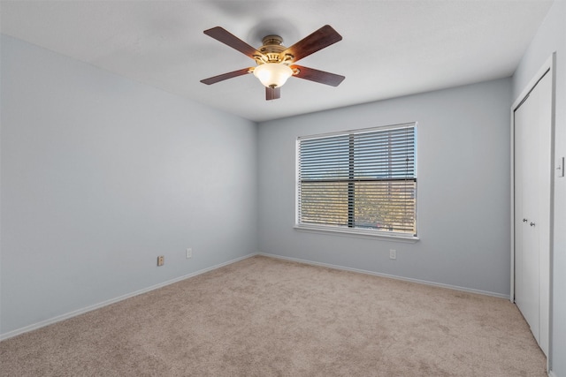 spare room featuring light carpet and ceiling fan