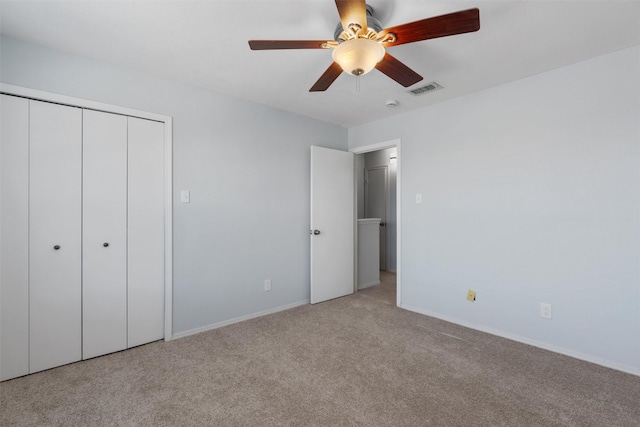 unfurnished bedroom with light colored carpet, ceiling fan, and a closet