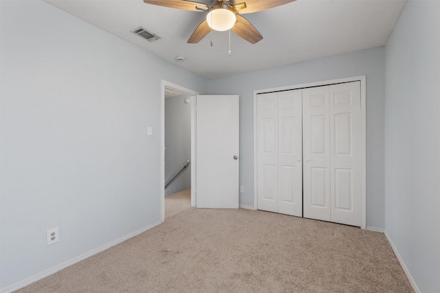 unfurnished bedroom with light colored carpet, a closet, and ceiling fan