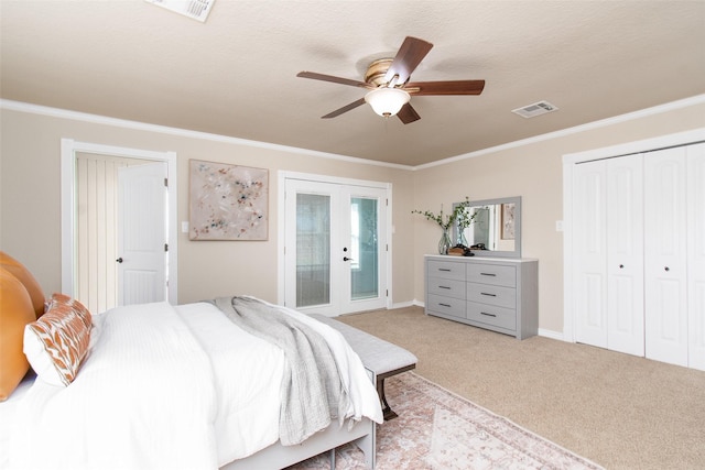 bedroom featuring french doors, ornamental molding, light colored carpet, ceiling fan, and a closet