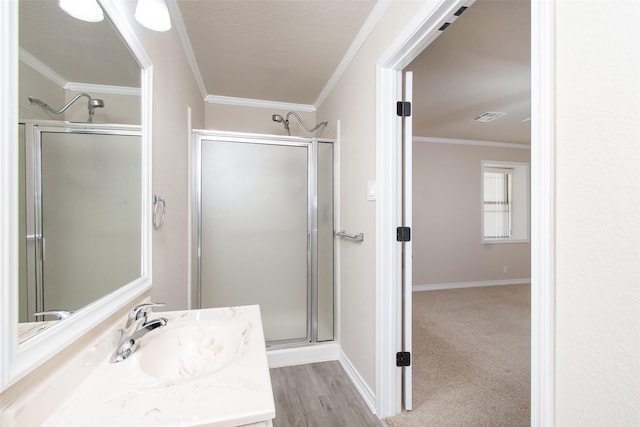 bathroom featuring crown molding, vanity, a shower with shower door, and hardwood / wood-style flooring