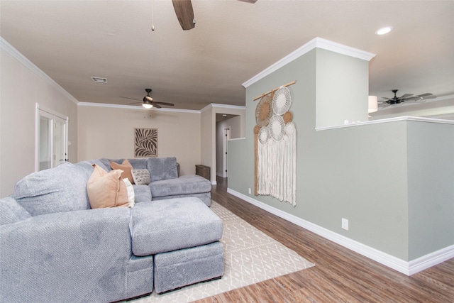 living room with hardwood / wood-style flooring, crown molding, and ceiling fan