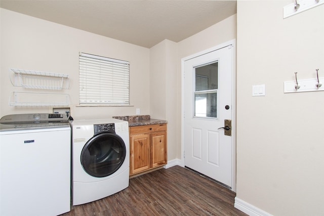 laundry room with cabinets, washing machine and clothes dryer, and dark hardwood / wood-style flooring