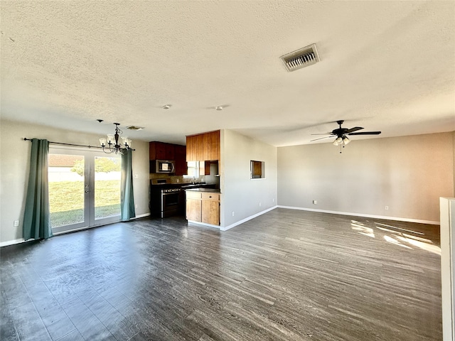 unfurnished living room featuring dark hardwood / wood-style flooring, ceiling fan with notable chandelier, and a textured ceiling