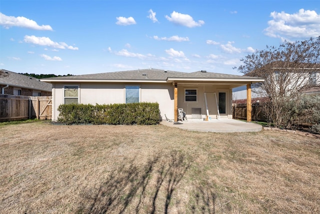 rear view of house with a patio and a lawn