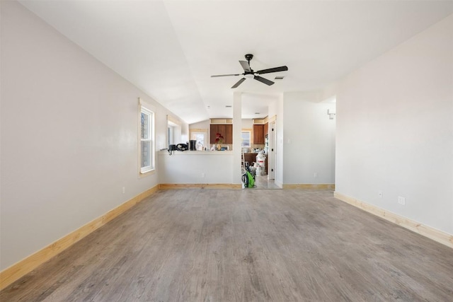 1016 Flanagan Dr, Leander, TX 78641 - unfurnished living room with light wood finished floors, a ceiling fan, and vaulted ceiling