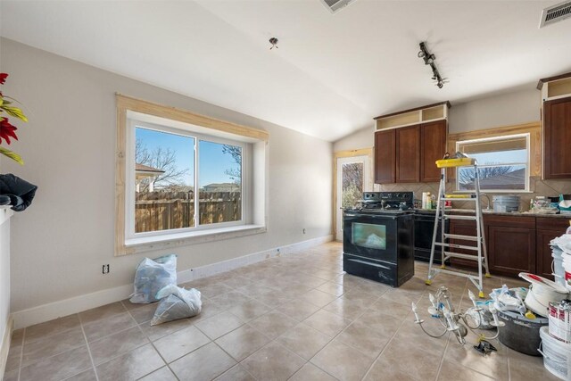 1016 Flanagan Dr, Leander, TX 78641 - kitchen with black stove, healthy amount of natural light, decorative backsplash, vaulted ceiling, and light tile patterned flooring