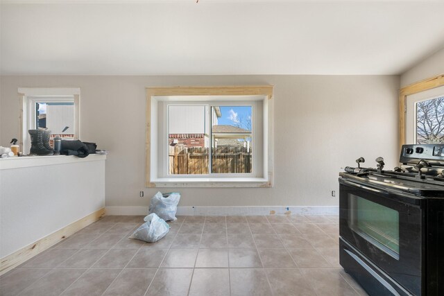 kitchen with black range with electric stovetop, light tile patterned floors, and a wealth of natural light