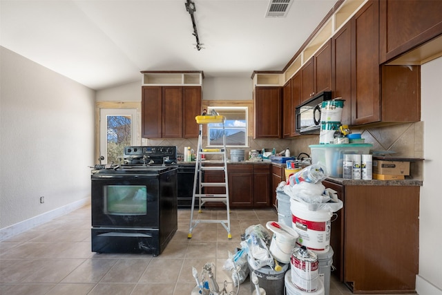 kitchen featuring rail lighting, lofted ceiling, backsplash, light tile patterned floors, and black appliances