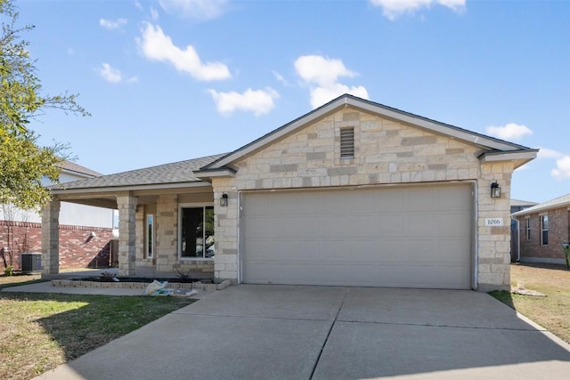 1016 Flanagan Dr, Leander, TX 78641 - ranch-style home featuring stone siding, concrete driveway, a garage, and a shingled roof