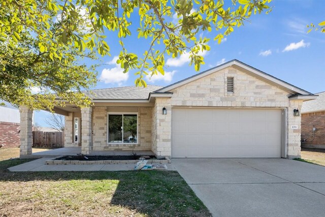 1016 Flanagan Dr, Leander, TX 78641 - ranch-style house with driveway, a garage, stone siding, and brick siding