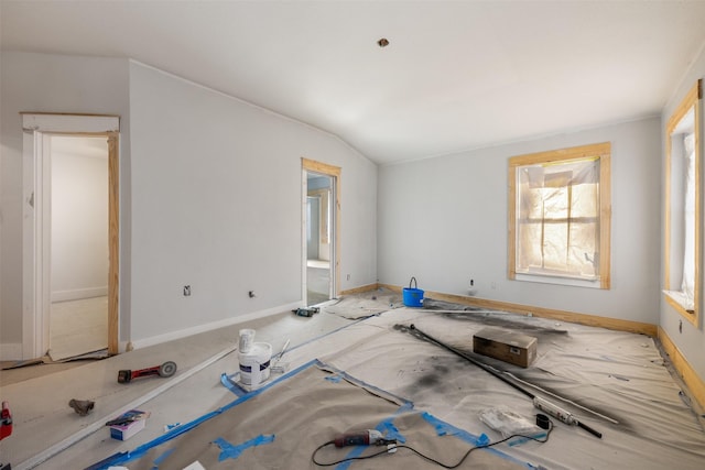 unfurnished room with vaulted ceiling