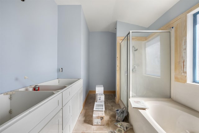 bathroom featuring tile patterned flooring, vaulted ceiling, and independent shower and bath