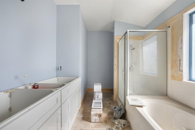 1016 Flanagan Dr, Leander, TX 78641 - full bathroom featuring a stall shower, a garden tub, vaulted ceiling, and tile patterned floors