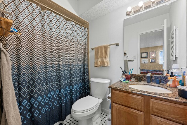 bathroom featuring vanity, toilet, and a textured ceiling