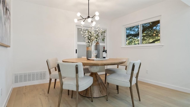 dining space with a notable chandelier and light hardwood / wood-style flooring