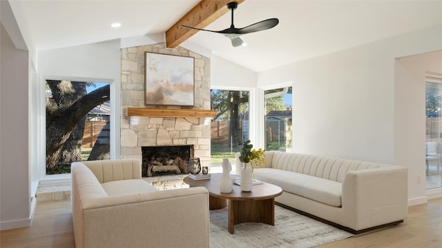 living room with ceiling fan, a fireplace, light hardwood / wood-style flooring, and vaulted ceiling with beams