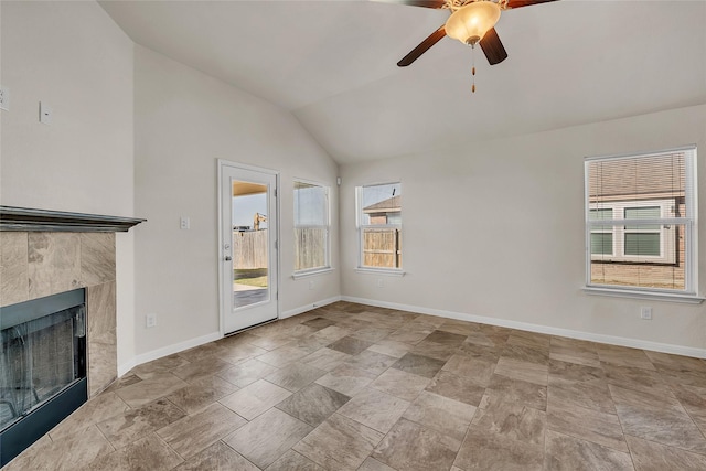 unfurnished living room with ceiling fan, a tiled fireplace, and vaulted ceiling